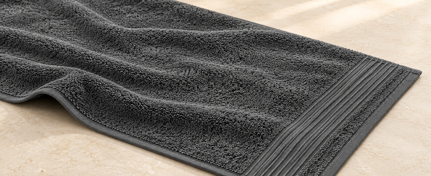 Close-up of a Denica Home 600 GSM cotton towel showing loops, its single wide woven border, and finished edge.