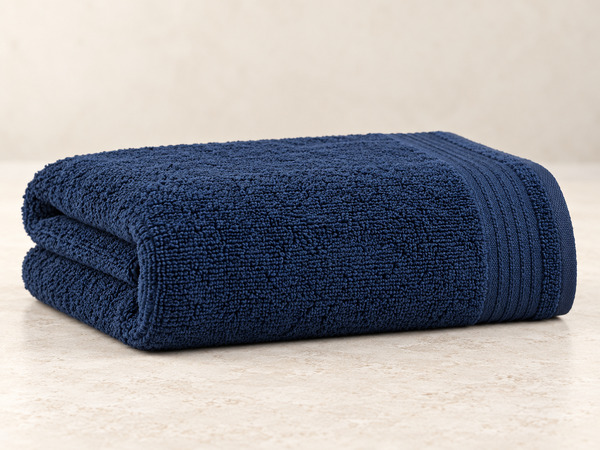 Folded navy Denica Home towel showing its plush thickness.
